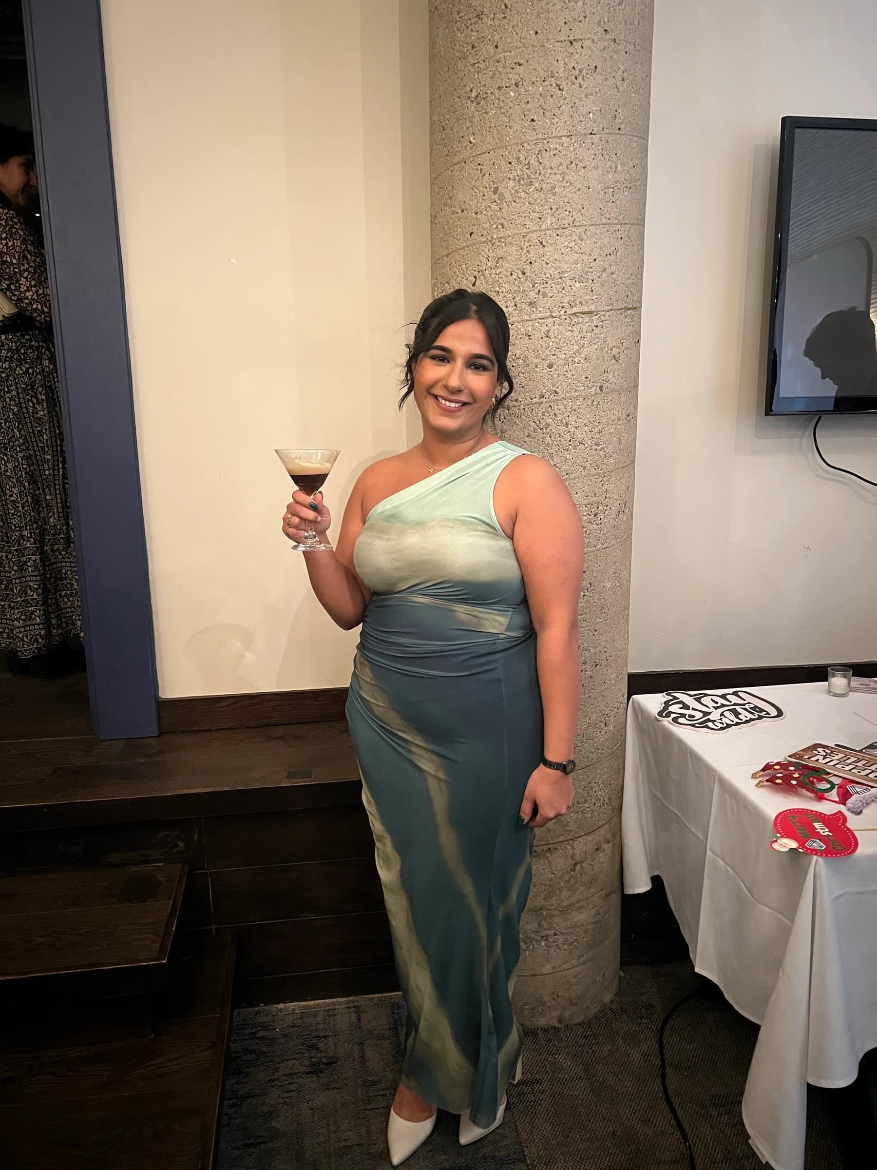 Sheena Tatla smiling in a sage and teal dress.
